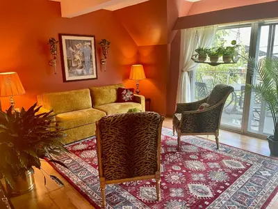 a living room with orange walls and a couch and chairs at Big apartment by the Farmers market in Kitchener