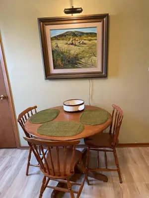 a wooden table with chairs and a painting on the wall at Big apartment by the Farmers market in Kitchener