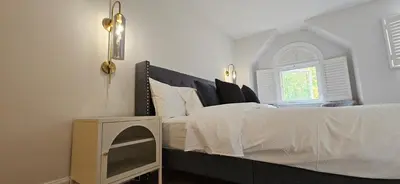 a white bedroom with a bed with a window at Cozy 3BR Retreat with Dedicated Work table and Parking in Toronto