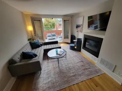 a living room with a couch and a table at Cozy 3BR Retreat with Dedicated Work table and Parking in Toronto