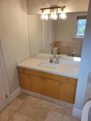 a bathroom with a sink and a mirror at Cozy 3BR Retreat with Dedicated Work table and Parking in Toronto