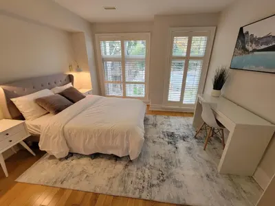a bedroom with a bed and a desk and windows at Cozy 3BR Retreat with Dedicated Work table and Parking in Toronto