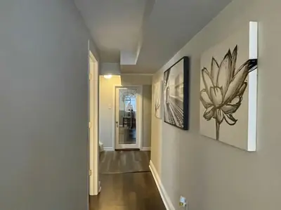 a hallway with two pictures on the wall and a hallway sidx sidx sidx at 2 bedroom rental apartment , 1 sofa bed, 2 car parking in Mississauga