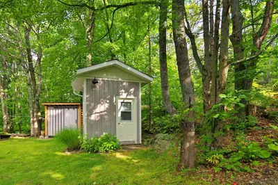 a small shed sitting in the middle of a yard at Muskoka Retreat, Fire Pit, Games, Waterfront in Gravenhurst