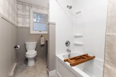 a white bathroom with a toilet and a sink at 4Bdrm Muskoka Retreat, Fire Table, Games, Netflix in Port Carling