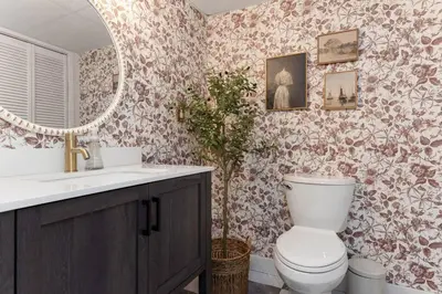 a bathroom with a toilet and a sink and a mirror at 4Bdrm Muskoka Retreat, Fire Table, Games, Netflix in Port Carling