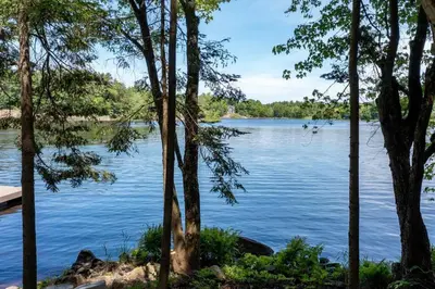a view of a lake through a group of trees at 4Bdrm Muskoka Retreat, Fire Table, Games, Netflix in Port Carling