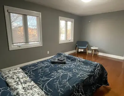 a bedroom with a large bed and two windows at Family-Friendly Retreat for 14 in Richmond Hill in Richmond Hill