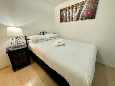 a bedroom with a bed with two shoes on it at Corner suite Courtyard view 4 real beds in Toronto