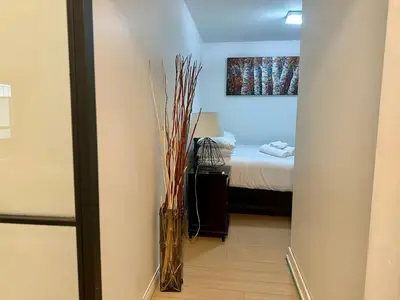 a room with a bed and a vase with sticks at Corner suite Courtyard view 4 real beds in Toronto