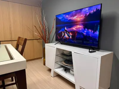 a flat screen tv sitting on top of a white entertainment center at Corner suite Courtyard view 4 real beds in Toronto