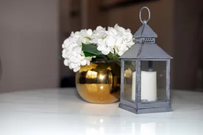 a candle and a vase of flowers and a lantern at Beautiful House 2 bedroom in Belleville