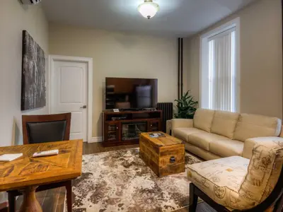 a living room with a couch and a tv at Western Hotel & Executive Suites in Guelph