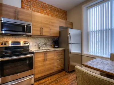 a kitchen with wooden cabinets and stainless steel appliances at Western Hotel & Executive Suites in Guelph