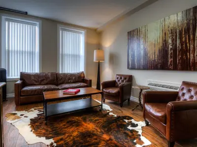 a living room with leather couches and a coffee table at Western Hotel & Executive Suites in Guelph