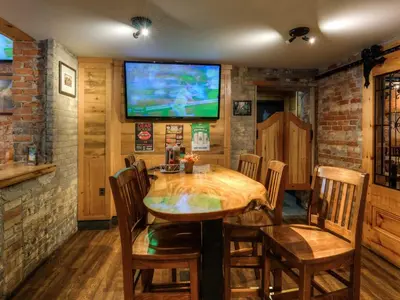 a dining room with a wooden table and a tv at Western Hotel & Executive Suites in Guelph