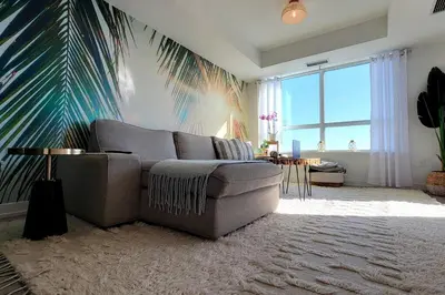 a living room with a couch and a palm tree mural at Lakeview Escape Endy KING BED in Pickering