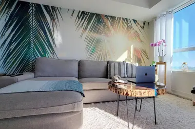 a living room with a couch and a table with a laptop at Lakeview Escape Endy KING BED in Pickering