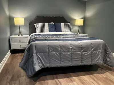 a bedroom with a large bed with two lamps at Fully Furnished Guest Suite in Richmond Hill
