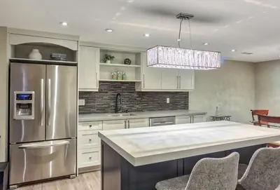 a kitchen with white cabinets and a stainless steel refrigerator at Fully Furnished Guest Suite in Richmond Hill