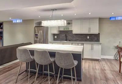 a kitchen with a island with chairs around it at Fully Furnished Guest Suite in Richmond Hill