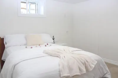 a white bed with a blanket on top of it at Exclusive Private Basement in London
