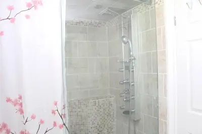 a shower stall in a bathroom with a shower curtain at Exclusive Private Basement in London