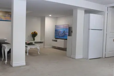 a white room with a refrigerator and a table at Exclusive Private Basement in London