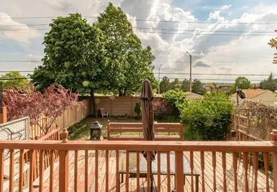 a wooden deck with a bench and an umbrella at Home away from home in Brampton