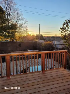 a wooden deck with the sun setting in the background at Home away from home in Brampton
