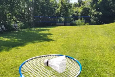 a tennis racket laying on the grass in a yard at Summer Getaway with Pool and Nearby Attractions in Cobourg