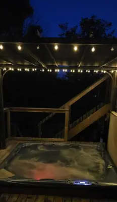a hot tub with lights on a deck at night at Summer Getaway with Pool and Nearby Attractions in Cobourg