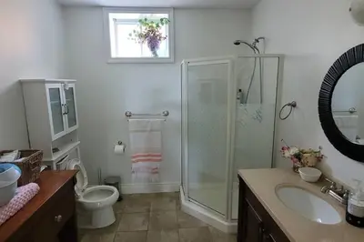 a bathroom with a shower and a toilet and a sink at Summer Getaway with Pool and Nearby Attractions in Cobourg