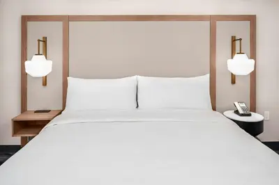 a bedroom with a large white bed and two lights at Fairfield by Marriott Inn & Suites Gravenhurst Muskoka in Gravenhurst