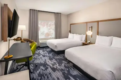 a hotel room with two beds and a desk and a television at Fairfield by Marriott Inn & Suites Gravenhurst Muskoka in Gravenhurst