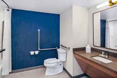 a bathroom with a toilet and a blue wall at Fairfield by Marriott Inn & Suites Gravenhurst Muskoka in Gravenhurst