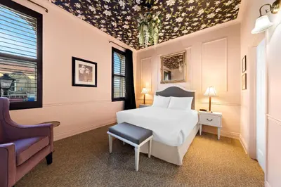 a bedroom with a white bed and a chair at The Arlington Hotel - BW Signature Collection in Paris