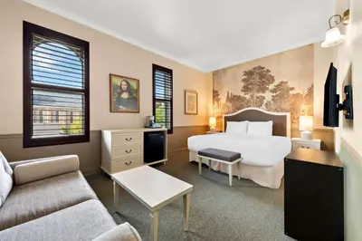 a hotel room with a bed and a couch at The Arlington Hotel - BW Signature Collection in Paris