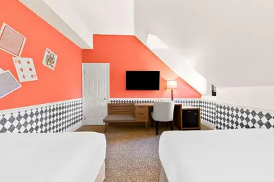 a room with two beds and a tv on a wall at The Arlington Hotel - BW Signature Collection in Paris