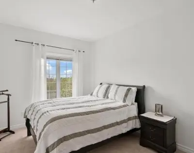 a white bedroom with a bed and a window at Summer Getaway with Pool and Nearby Attractions in Cobourg