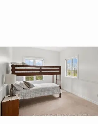 a bedroom with a bunk bed and two windows at Summer Getaway with Pool and Nearby Attractions in Cobourg