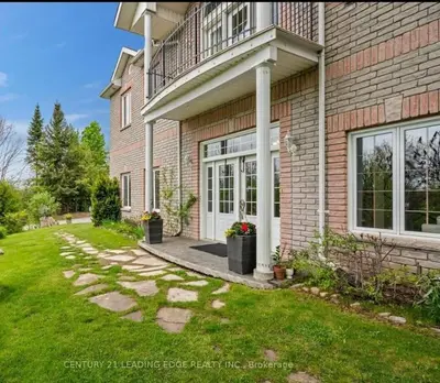 a brick house with a walkway leading to the front door at Summer Getaway with Pool and Nearby Attractions in Cobourg