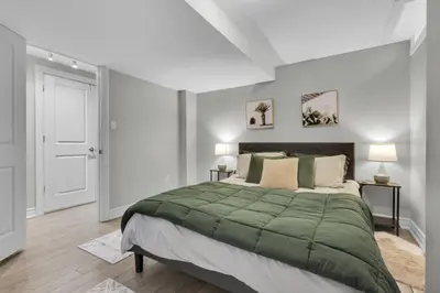 a bedroom with a large bed with a green blanket at 6BR house near Shops, Transit, Hwy and GO in Mississauga