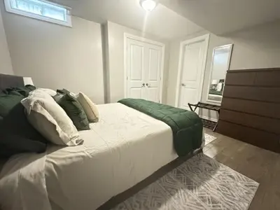 a bedroom with a large bed and a dresser at 6BR house near Shops, Transit, Hwy and GO in Mississauga