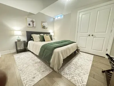 a bedroom with a large bed with a green blanket at 6BR house near Shops, Transit, Hwy and GO in Mississauga
