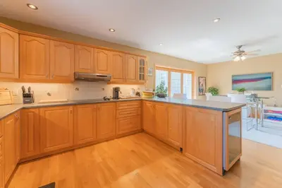 a kitchen with wooden cabinets and a large island at Luxury Hillside Farmhouse on The Bay of Quinte in Belleville