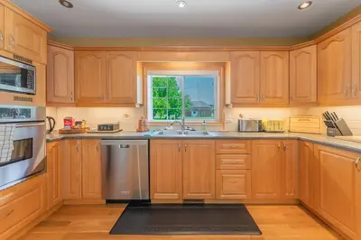 a kitchen with wooden cabinets and a window at Luxury Hillside Farmhouse on The Bay of Quinte in Belleville