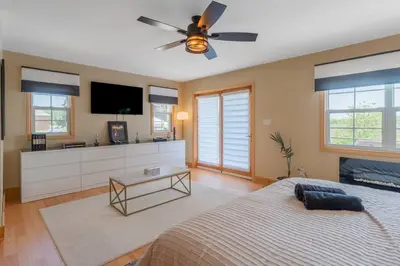 a bedroom with a bed and a flat screen tv at Luxury Hillside Farmhouse on The Bay of Quinte in Belleville