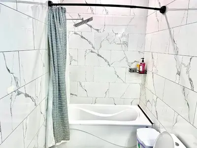 a bathroom with white marble walls and a bath tub at Private Room In Cambridge B9 in Cambridge