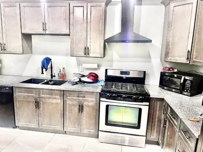 a kitchen with wooden cabinets and a stove top oven at Private Room In Cambridge B9 in Cambridge